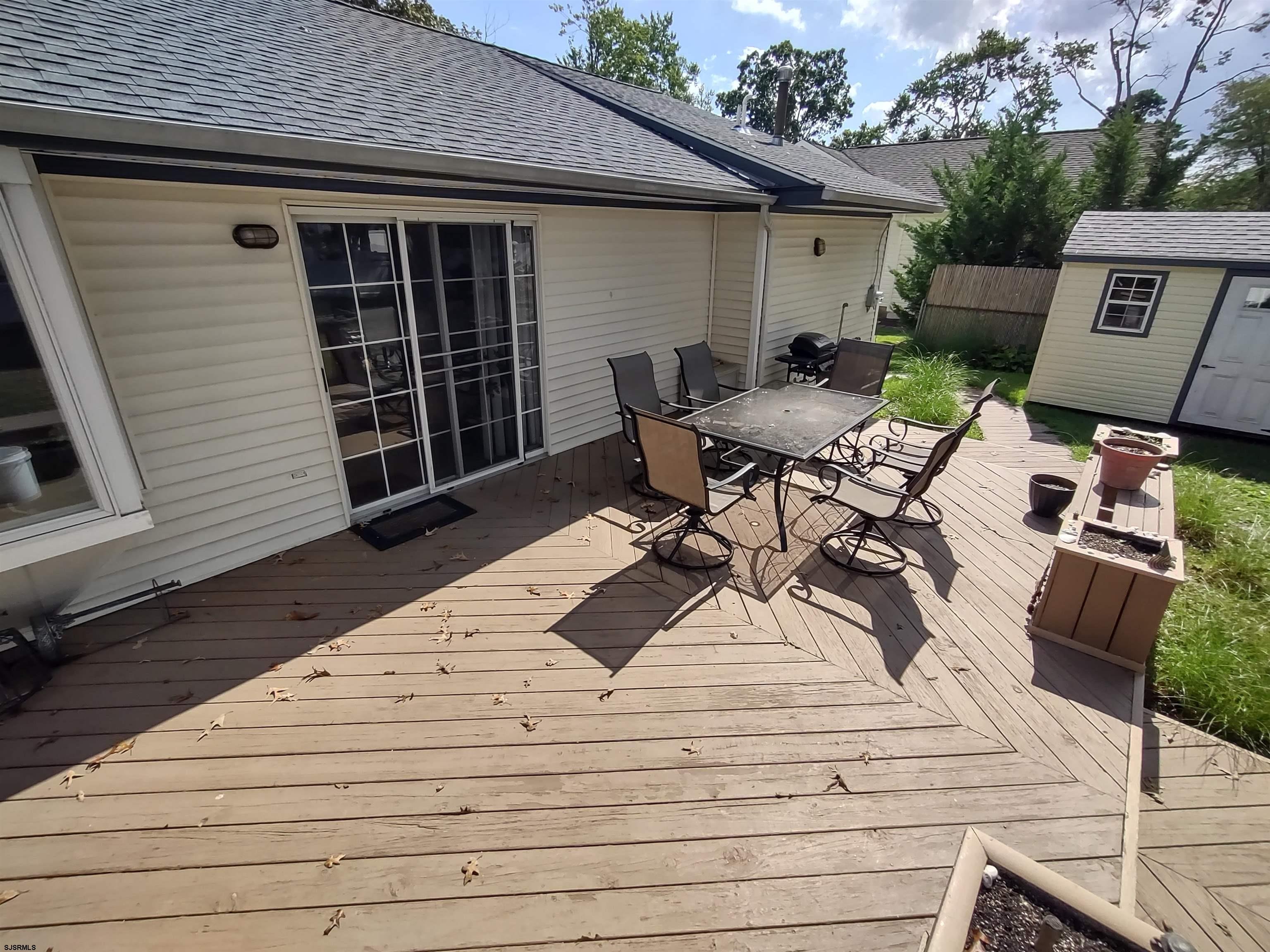 12 Osborne Road Somers Point, NJ 08244 - Photo 12 of 15 a view of a patio with table and chairs with wooden floor and fence