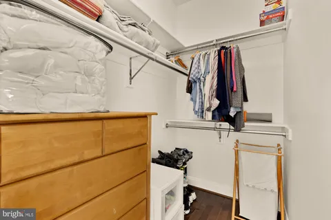 a view of walk in closet with clothes and shoes