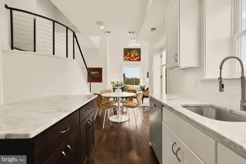 a kitchen with a table chairs in it and wooden floors