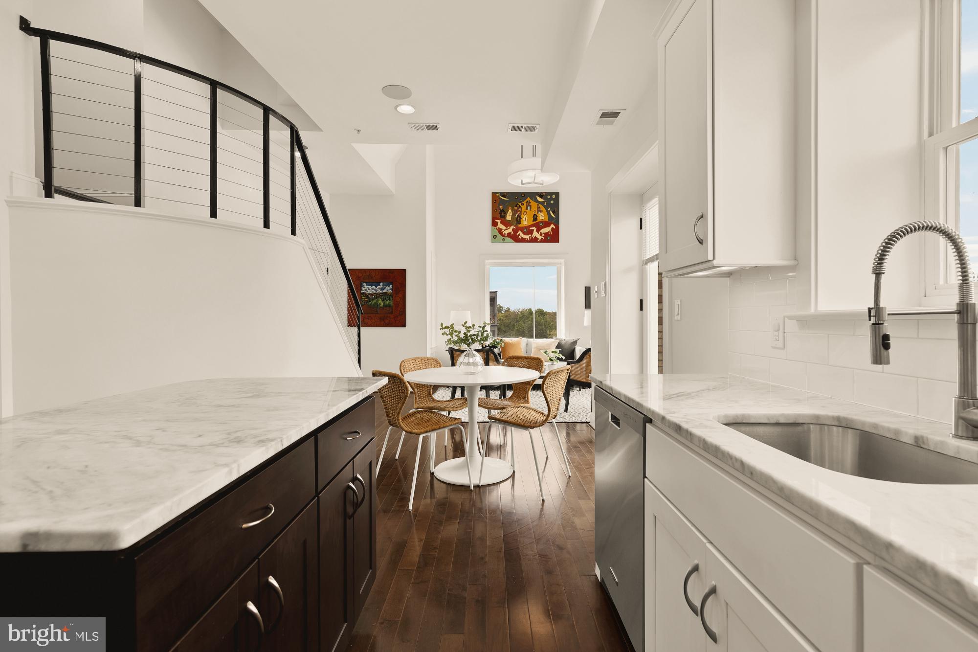 1249 Kenyon Street Northwest, Unit 4 Washington, DC 20010 - Photo 9 of 30 a kitchen with a table chairs in it and wooden floors