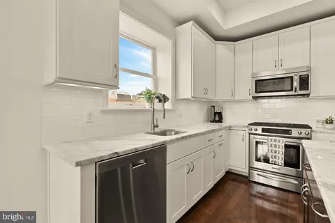 a kitchen with stainless steel appliances granite countertop a sink stove and microwave