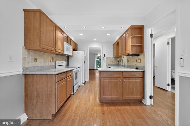 a large kitchen with stainless steel appliances granite countertop a large stove a sink dishwasher and a refrigerator with wooden floor