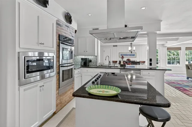 a kitchen with stainless steel appliances granite countertop a sink a stove and a refrigerator