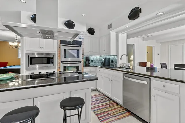 a kitchen with stainless steel appliances a sink a stove and a refrigerator