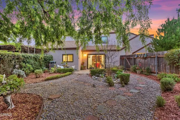 a front view of a house with a yard and shrubs
