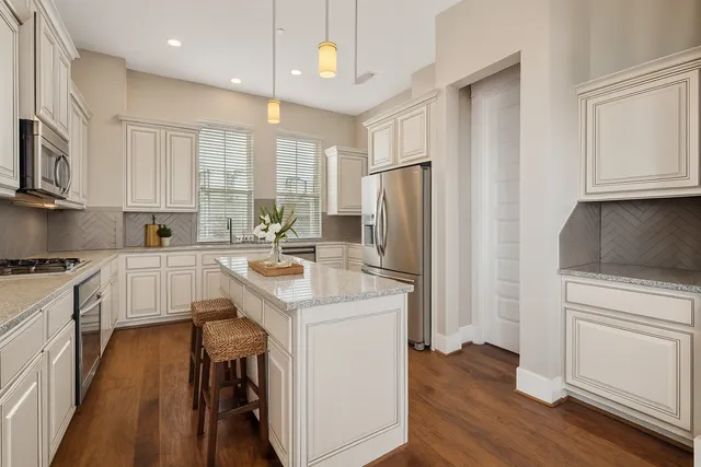 a kitchen with white cabinets and refrigerator