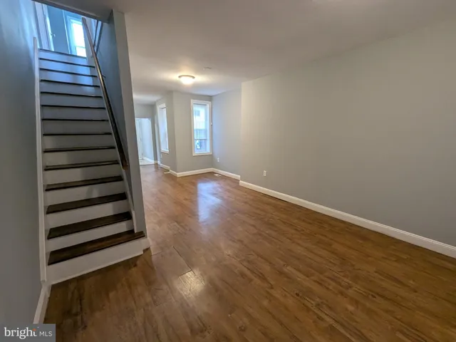 a view of hallway with window and wooden floor