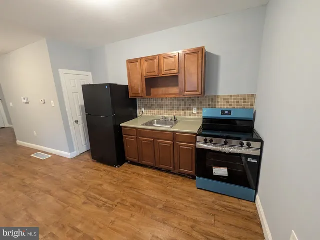 a kitchen with wooden floors appliances