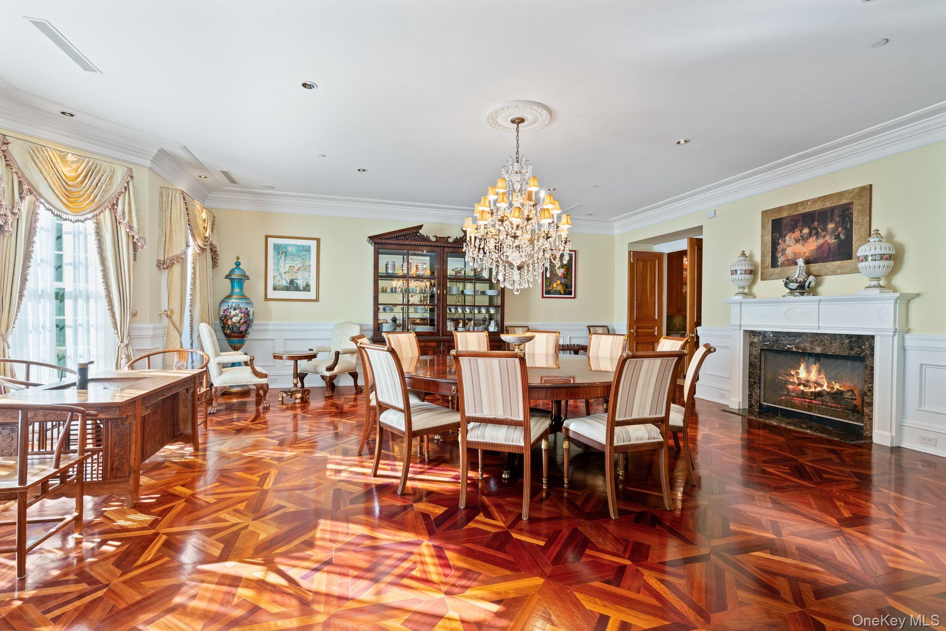 660 Chicken Valley Road Locust Valley, NY 11560 - Photo 13 of 48 Open-concept room featuring intricate parquet wood-finish flooring, a white-mantled fireplace, and a crystal chandelier