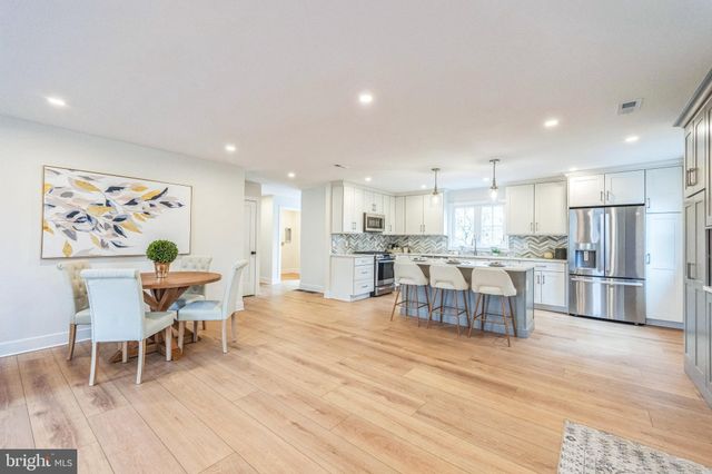a living room with stainless steel appliances kitchen island granite countertop furniture and wooden floor