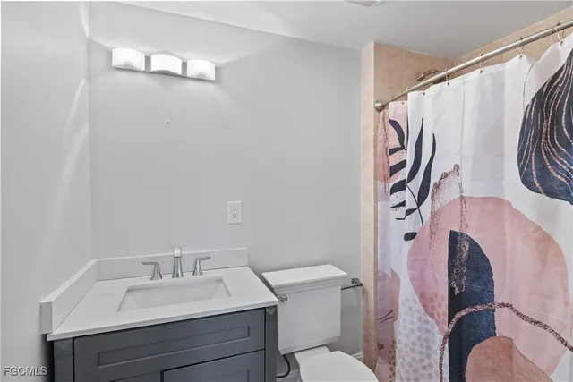 a bathroom with a sink mirror vanity and toilet
