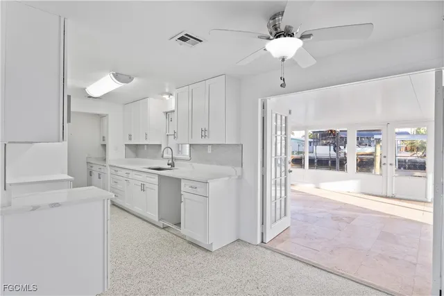 a large white kitchen with cabinets