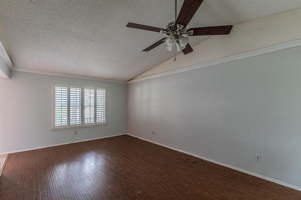 6504 Johnnie Street Watauga, TX 76148 - Photo 9 of 23 Room featuring wood-finish flooring, white walls, and a vaulted ceiling with crown molding