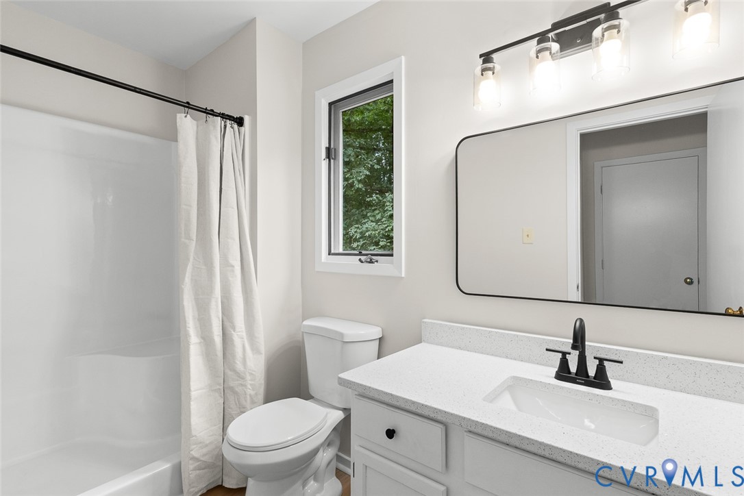 12916 Copperas Lane Henrico, VA 23233 - Photo 15 of 26 a bathroom with a sink a mirror a toilet and a window