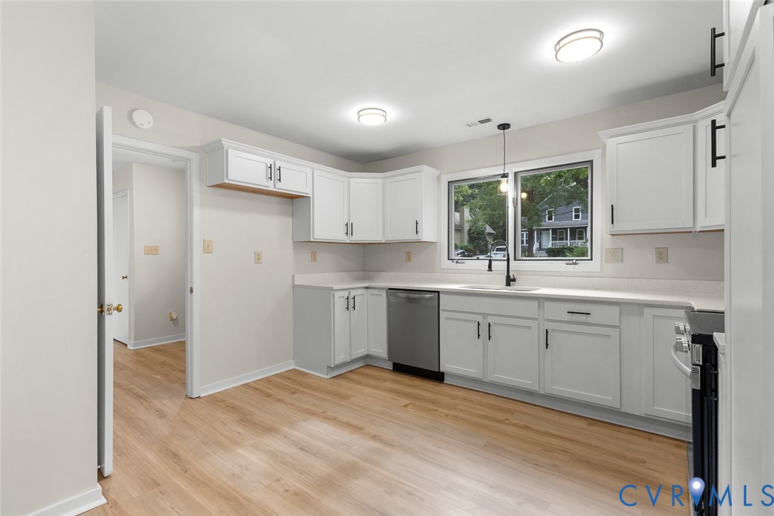 12916 Copperas Lane Henrico, VA 23233 - Photo 8 of 26 a kitchen with white cabinets a sink a window and stainless steel appliances