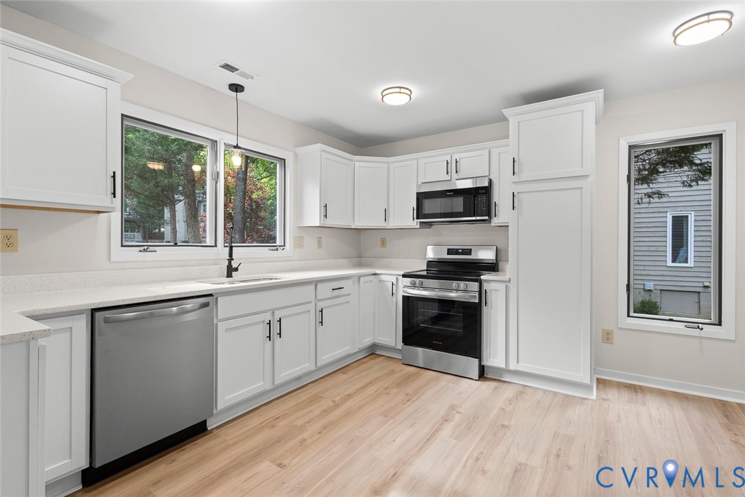 12916 Copperas Lane Henrico, VA 23233 - Photo 9 of 26 a kitchen with granite countertop a stove top oven a sink dishwasher and a refrigerator with wooden floor
