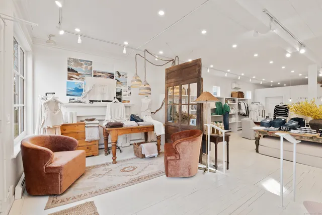 a living room with furniture a rug and white walls