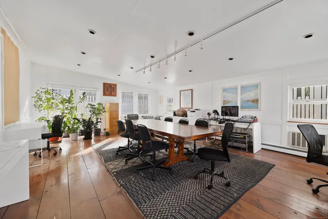 a living room with dining room and wooden floor