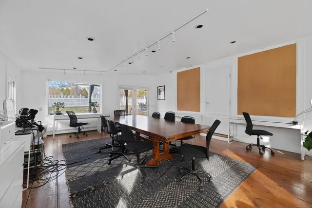 a hallway with front door wooden floor and windows