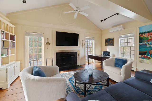 a living room with furniture a fireplace and a flat screen tv