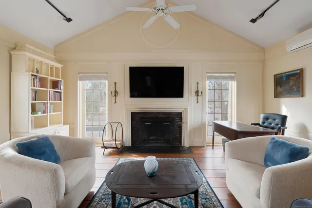 a living room with furniture a fireplace and a flat screen tv