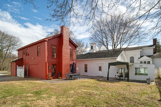 a view of a house with a big yard and large tree