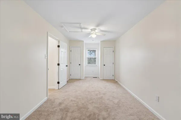 an empty room with a ceiling fan and a window