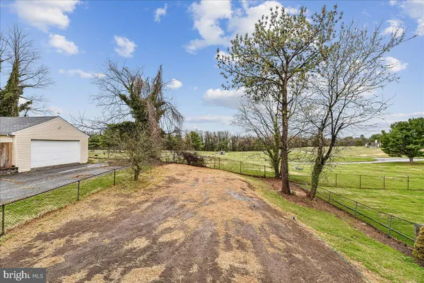 a view of backyard with wooden fence and a bench