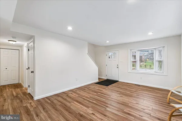 a view of a big room with wooden floor and entryway