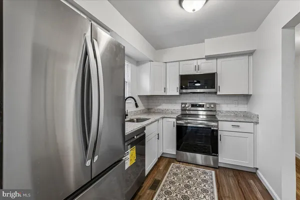 a kitchen with stainless steel appliances granite countertop a refrigerator stove top oven and sink