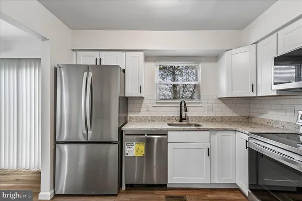 a kitchen with appliances a refrigerator and a sink