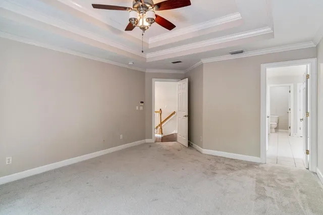 a view of an empty room and chandelier fan