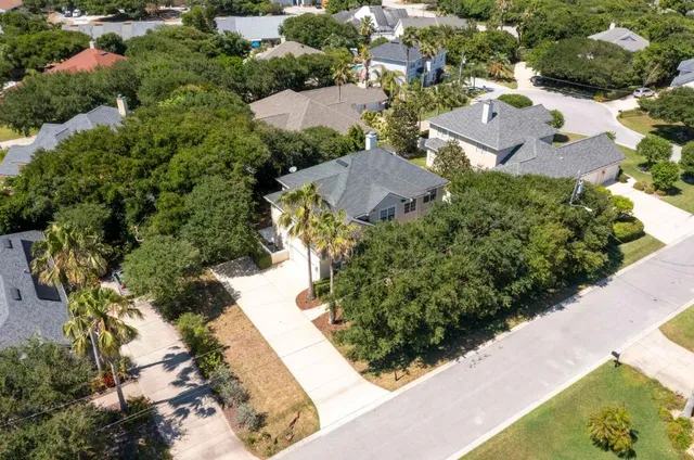 an aerial view of a house with a yard and greenery