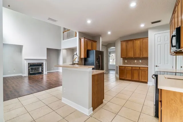 a kitchen with kitchen island granite countertop a stove refrigerator and a sink