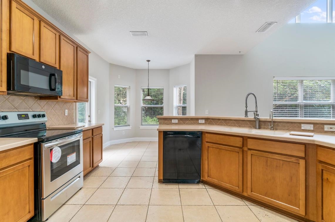 206 2nd Street St. Augustine, FL 32084 - Photo 8 of 32 a kitchen with stainless steel appliances granite countertop a stove a sink and a microwave