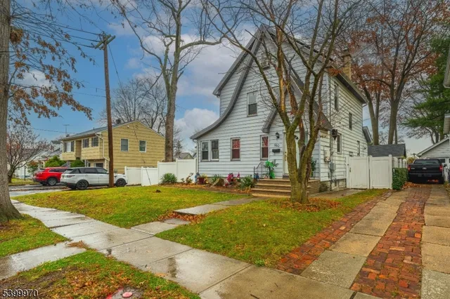 a view of a yard with cars parked in front of house