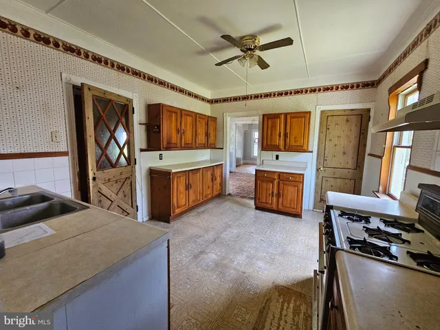 a living room with stainless steel appliances furniture a fireplace and a flat screen tv