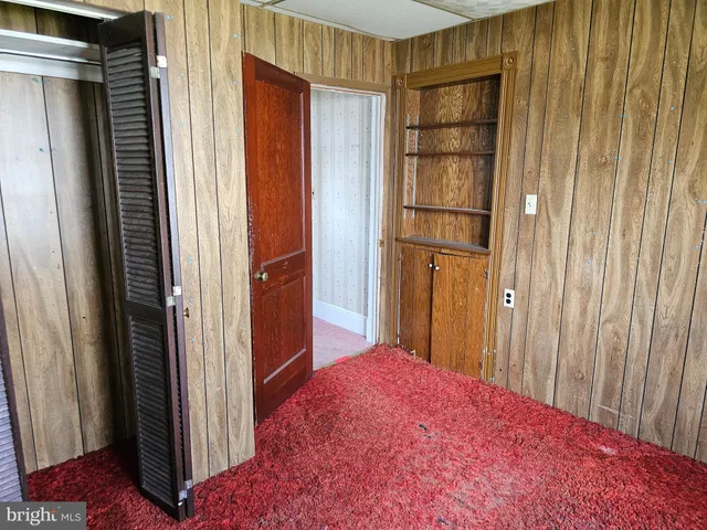 a view of a bedroom with a wooden walls