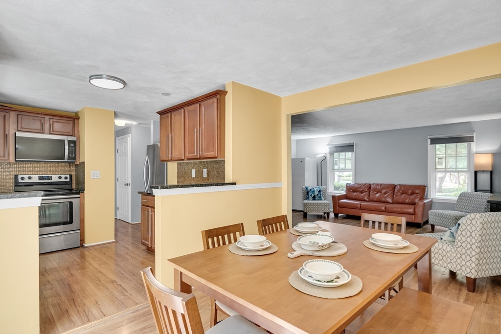 58 MacIntosh Lane, Unit 58 Boxborough, MA 01719 - Photo 8 of 23 a view of a dining room with furniture and wooden floor