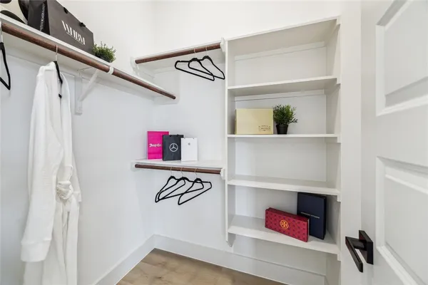 a view of walk in closet with clothes and shoes