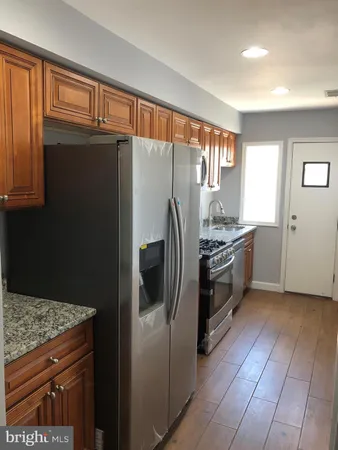 a kitchen with stainless steel appliances granite countertop a refrigerator and a sink