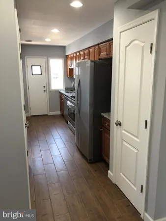 an empty room with wooden floor closet and windows