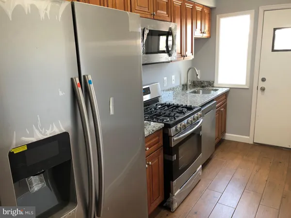 a kitchen with stainless steel appliances granite countertop a refrigerator and a stove