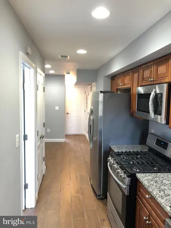 a kitchen with stainless steel appliances granite countertop a refrigerator and a stove