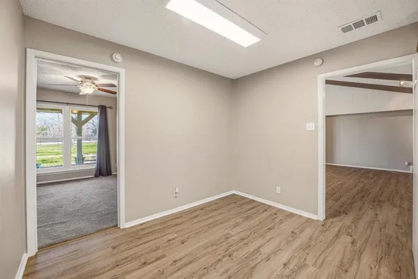 an empty room with wooden floor and a window
