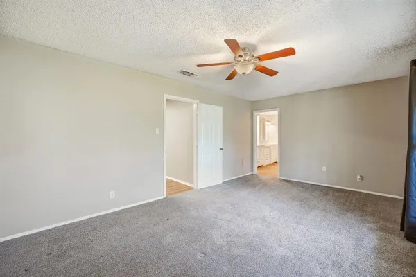 an empty room with windows and fan