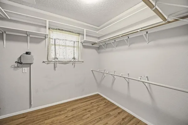 a view of walk in closet with empty racks