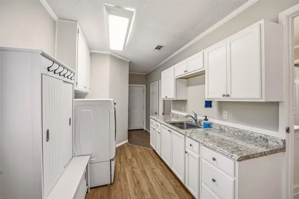 a kitchen with a sink a refrigerator and cabinets