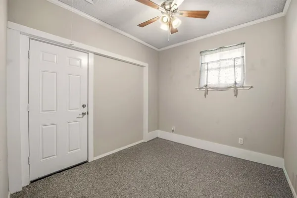 an empty room with windows and fan