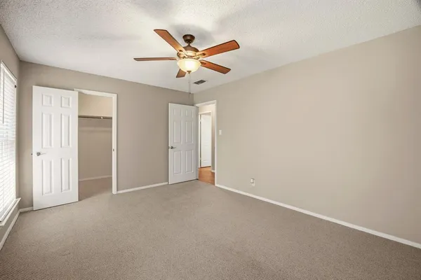 an empty room with closet and fan